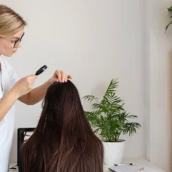 doctora con lupa viendo el pelo en una clinica capilar